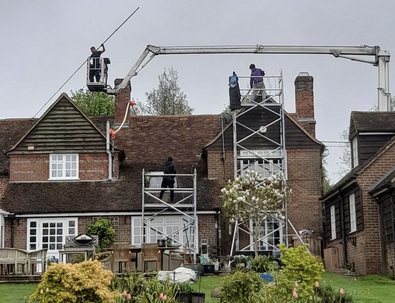 The Moss Cleaners using cherry picker and scaffolding to clean roof safely and professionally in Nailsworth, Gloucestershire